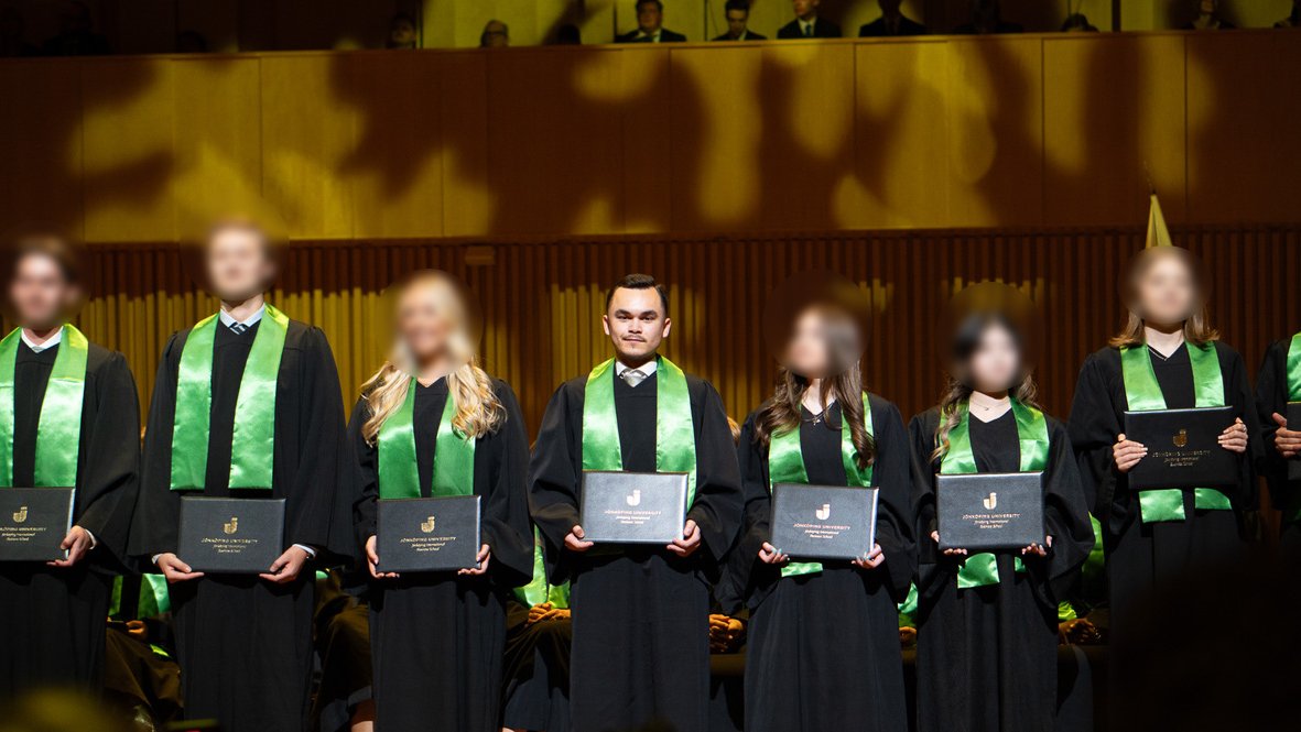 Adam Dahlqvist at the Jönköping University graduation ceremony, holding his diploma